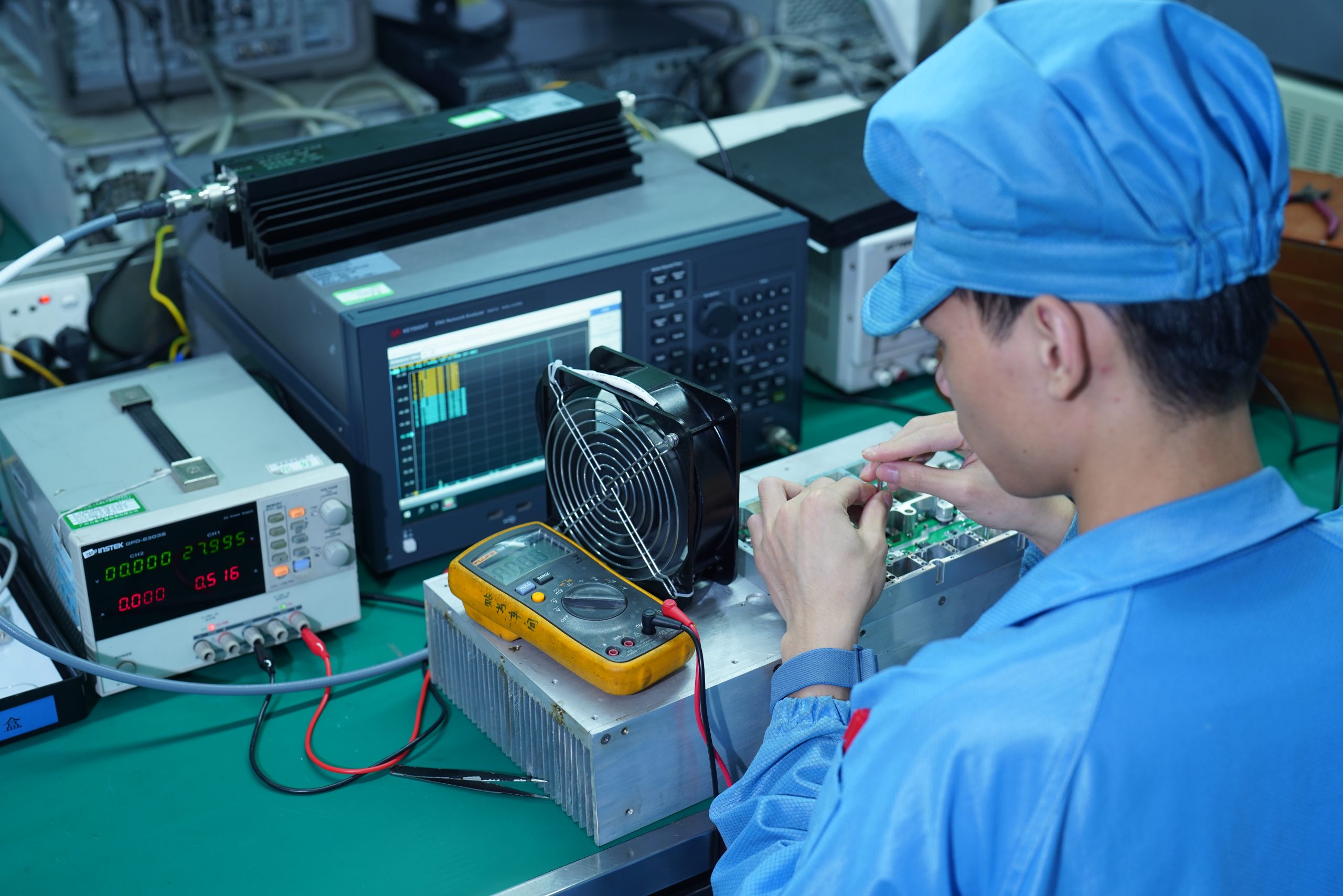 CorelixRF RF engineering lab — engineer operating VNA test bench with power amplifier module under measurement